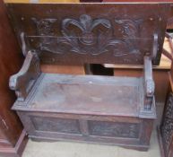 A 20th century oak monks bench with lions head arms above a box base