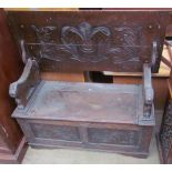 A 20th century oak monks bench with lions head arms above a box base