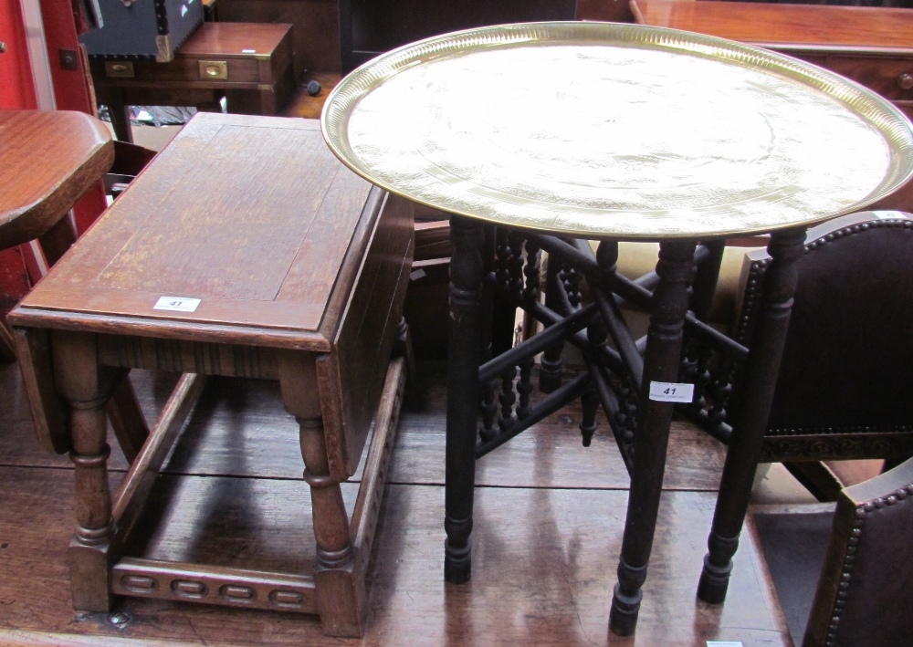 A brass topped occasional table on an ebonised folding base together with an oak occasional table