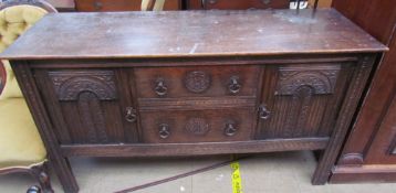 A 20th century oak sideboard with a carved front,