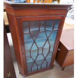 A George III mahogany hanging corner cupboard the moulded cornice above an ebony and boxwood strung