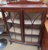 A 20th century walnut display cabinet with a pair of glazed doors with glazing bars on cabriole