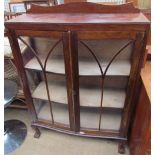 A 20th century walnut display cabinet with a pair of glazed doors with glazing bars on cabriole