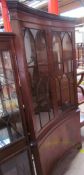 A reproduction mahogany standing corner cupboard of dished form with glazed cupboard doors and a