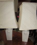 A pair of cream pottery table lamps together with a metal wine rack