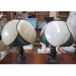 A pair of Tiffany style table lamps with marbled cream and green glass shades on naturalistic bases