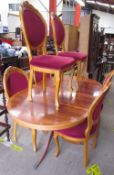 A modern yew wood dining suite comprising an extending dining table and six upholstered chairs