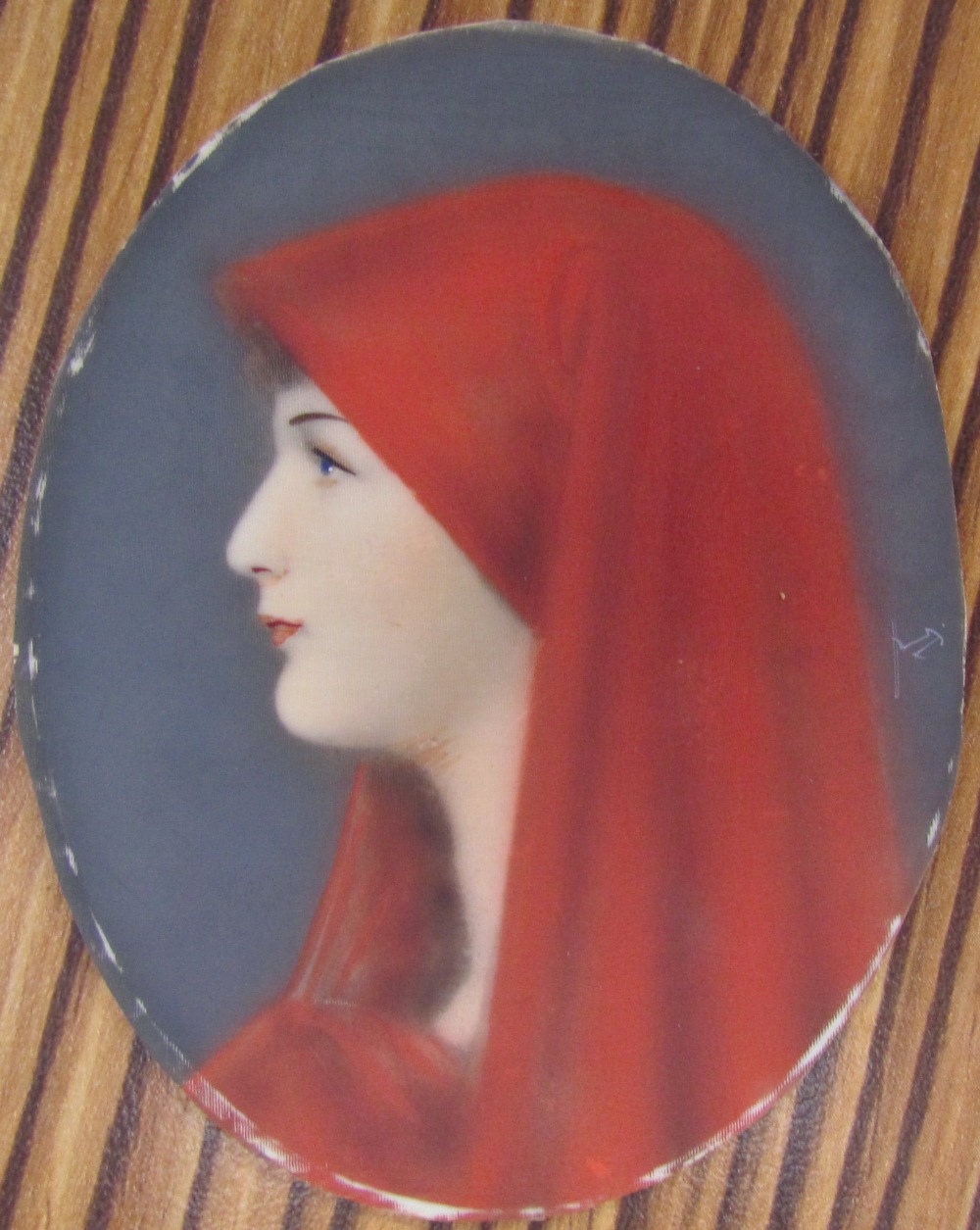 Head and shoulders portrait of a maiden in a red headdress together with a collection of miniatures