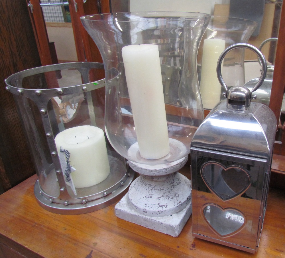 A white metal and glass cylindrical candle holder together with an urn shaped candle holder and a