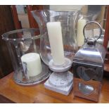 A white metal and glass cylindrical candle holder together with an urn shaped candle holder and a