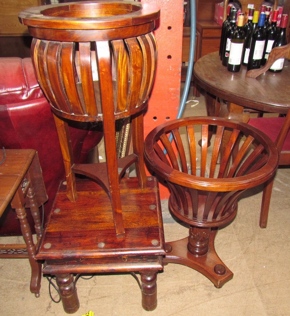 A modern mahogany plant stand with slatted sides on three legs,