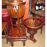 A modern mahogany plant stand with slatted sides on three legs,