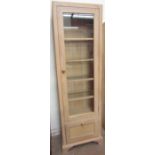 A modern limed oak display cabinet with a glazed door,
