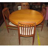 A mid 20th century teak extending dining table and four chairs,