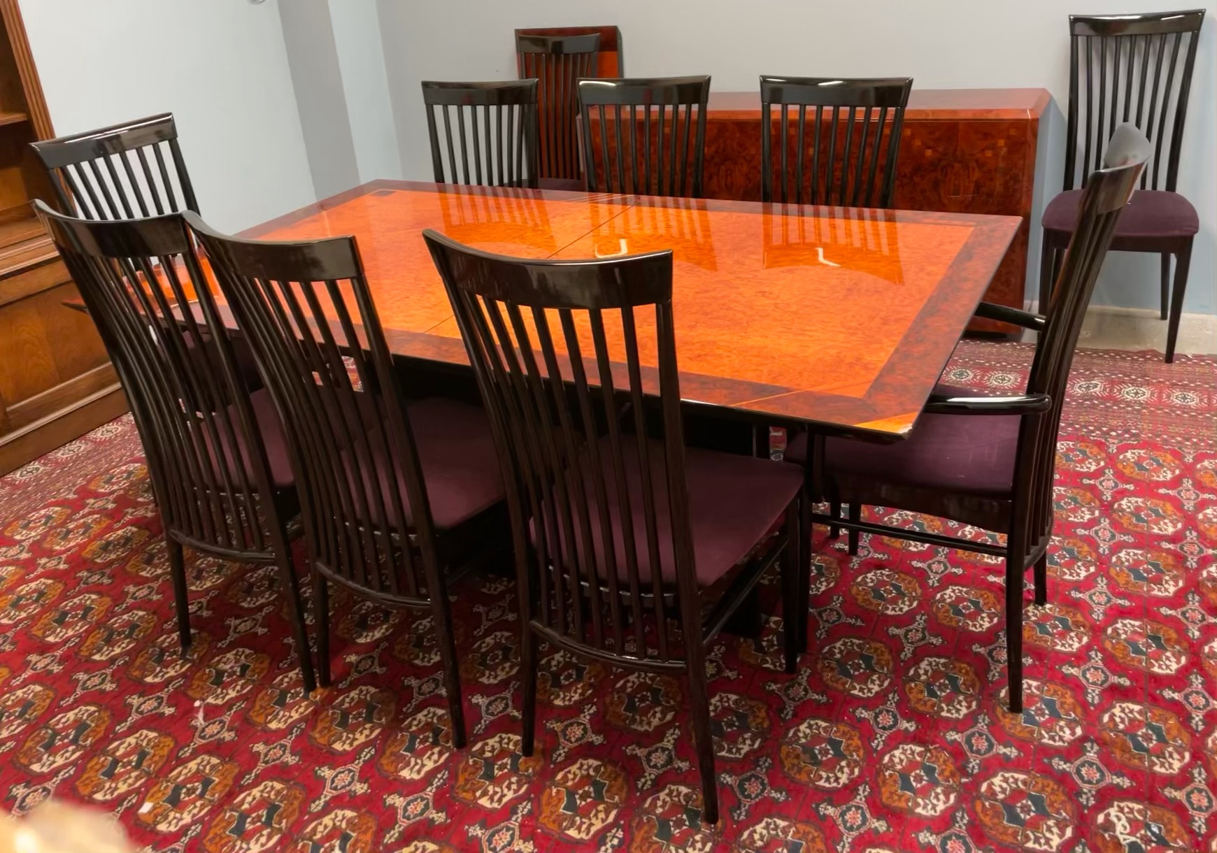 A high gloss modern dining suite with a figured walnut table and matching sideboard with ten high