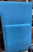A large turquoise upholstered padded head board,