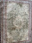 A modern rug with a green ground and central medallion to multiple guard stripes,
