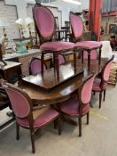 A reproduction mahogany extending dining table and eight chairs