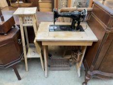 A Singer sewing machine table with a treadle base together with a pine torchere