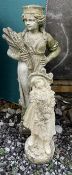 A reconstituted stone figure of a maiden holding a sheaf of corn together with another figure of a