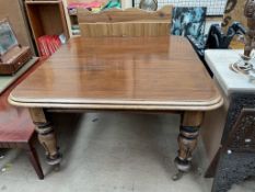 A Victorian mahogany extending dining table with a moulded top on leaf capped legs and casters,