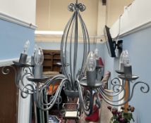 A scrolling grey metal eight branch chandelier