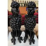 A pair of large model seated poodles in gloss black