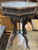 A mock Chinese carved occasional table with an octagonal top above drawers and a carved frieze with