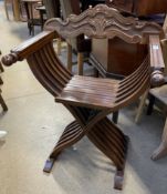 A modern Italian folding chair with a carved back and X frame legs