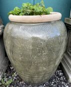 A large green glazed stoneware planter