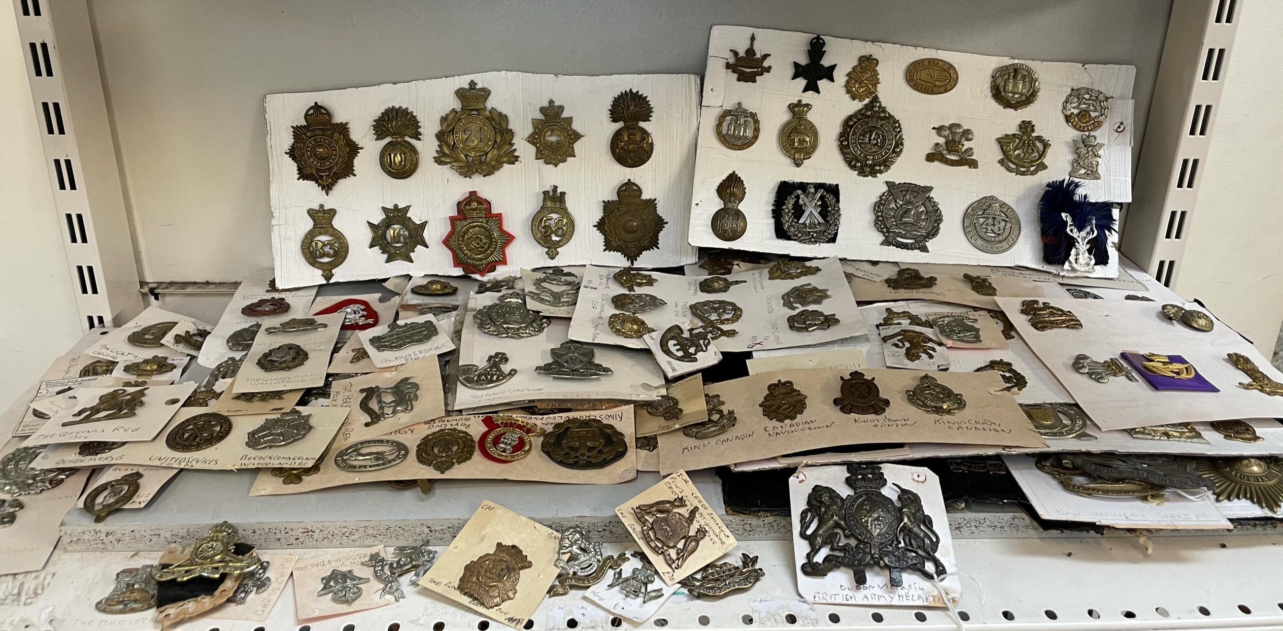 A collection of circa two hundred and fifty military cap badges including...