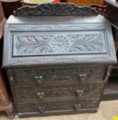 A 19th century Low Countries carved oak bureau, with a raised back, sloping fall,