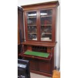 An Edwardian walnut secretaire bookcase, the moulded cornice above a pair of glazed doors,