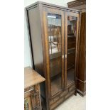 A 20th century mahogany effect display cabinet with glass doors and glass shelves above an