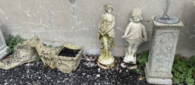 A reconstituted stone pedestal with sundial affixed to the top together with two figures of maidens,