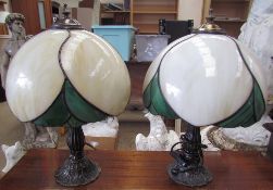 A pair of Tiffany style table lamps with marbled cream and green glass shades on naturalistic