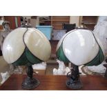 A pair of Tiffany style table lamps with marbled cream and green glass shades on naturalistic