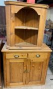 A pine side cabinet with a rectangular planked top above two drawers and two cupboards together