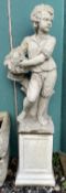 A reconstituted stone figure of a boy holding a basket of fruit on a plinth