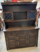 A 20th century oak dresser, the rack with a moulded cornice, shelves and a pair of glazed cabinets,