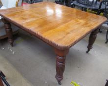 A late 19th / early 20th century oak dining table with a rectangular top and cut corners on