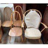 An Ercol elbow chair together with a set of three spindle back dining chairs