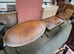 A reproduction mahogany leather inset coffee table of oval form on splayed legs together with