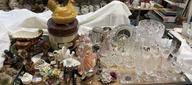 A cut glass bowl together with a decanter, assorted drinking glasses, decorative figures,