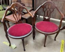 A pair of Edwardian mahogany elbow chairs with pierced splat above an oval pad seat on square legs