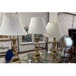 A set of three brass table lamps with baluster columns together with a magnifying mirror