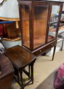 A reproduction mahogany display cabinet with a rectangular moulded top above glazed doors and sides,