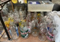 A collection of advertising milk bottles together with assorted postcards