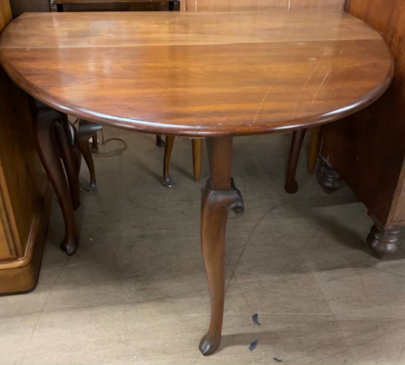 A 19th century mahogany gateleg dining table with an oval top on cabriole legs and pad feet