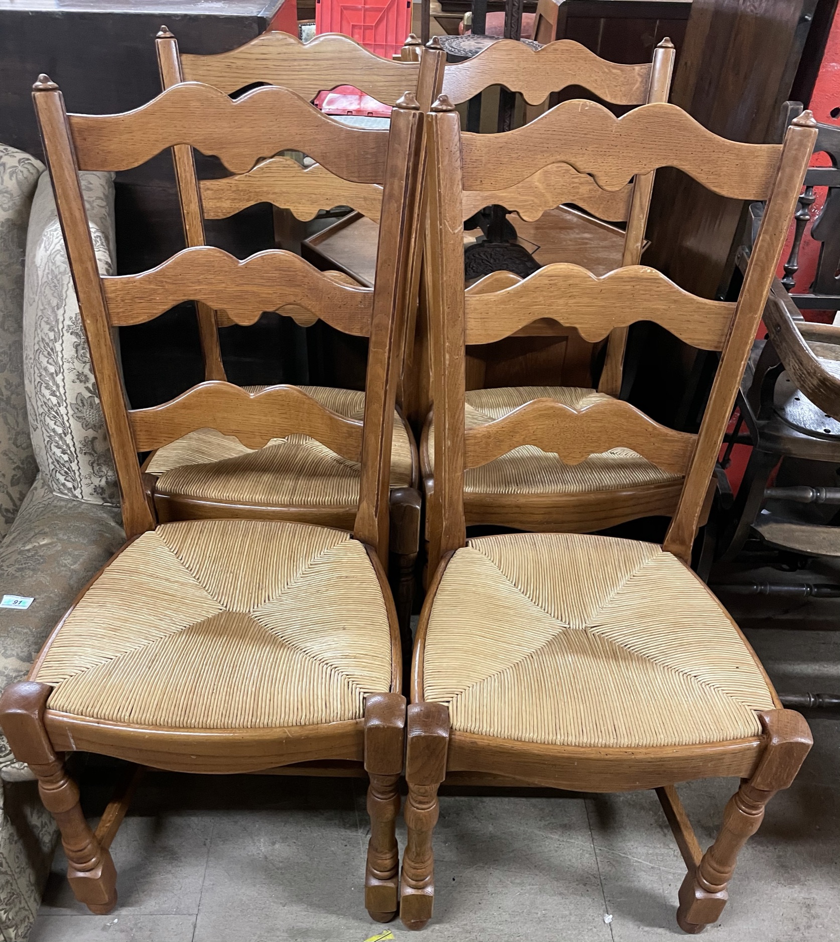 A set of four modern ladder back dining chairs with rush seats